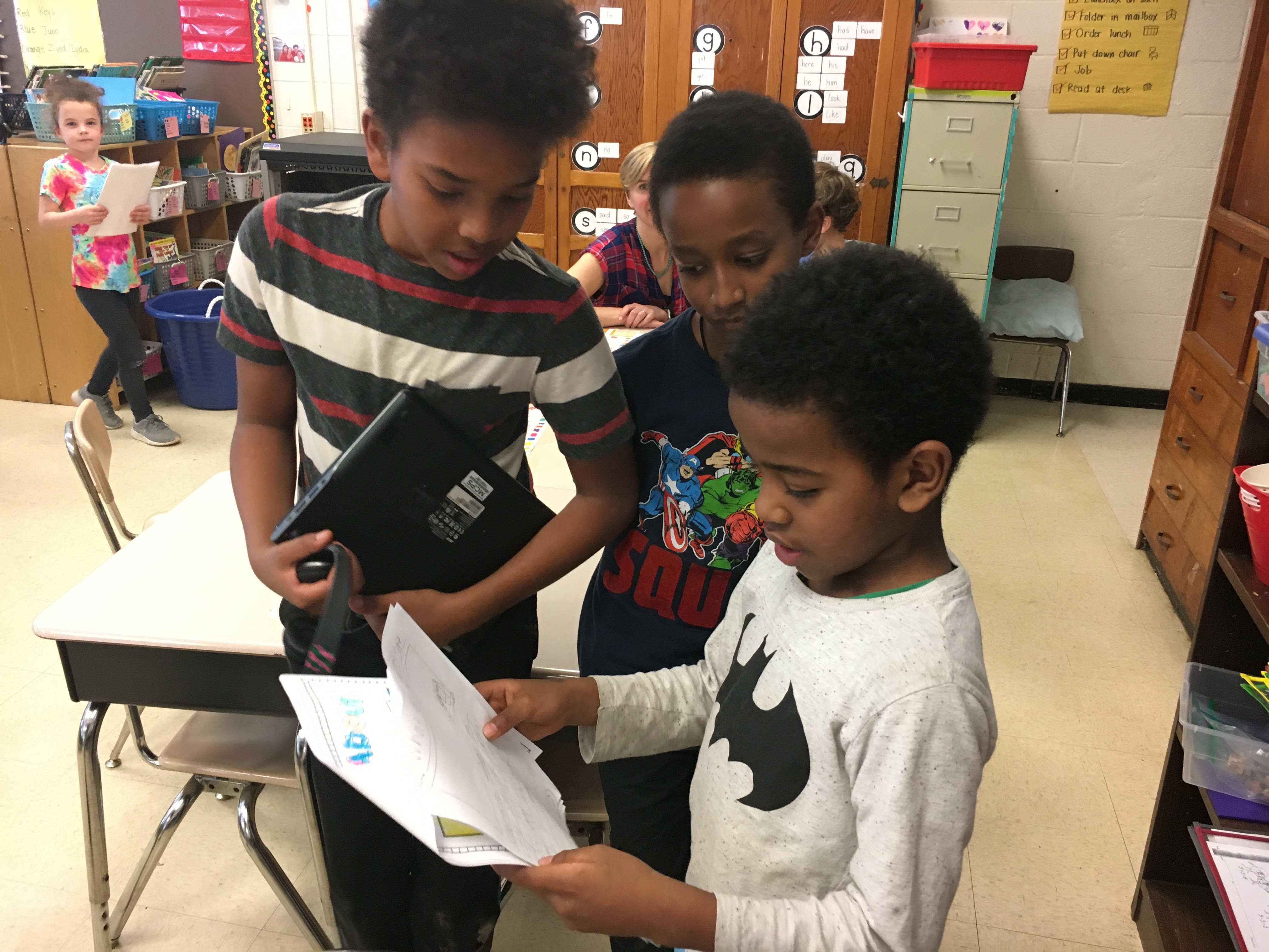 FIrst grade boy reads to fourth graders